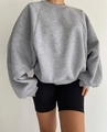 Close-up of the ribbed crewneck and raglan sleeve seams on a gray oversized sweatshirt - Gray