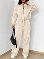 Detail view of the fine knitted fabric and pleated seam on beige two-piece sports tracksuit - S / Apricot