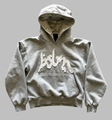 Detailansicht eines grauen Kapuzenpullovers mit weißer Buchstabenstickerei im Streetwear-Stil - XS / Grauer Blazer