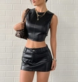 Detalle de un conjunto de dos piezas en cuero sintético negro con top y minifalda - S / Negro