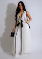 Detail van witte mouwloze jumpsuit met zwart contrast en grote bloem strik accent - S / Wit (G0690)