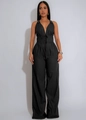 Details des schwarzen Halter-Jumpsuits mit V-Ausschnitt, Kordelzug und Metallösen am Träger - S / Schwarz