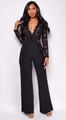 Detail eines schwarzen langärmeligen Jumpsuits mit Spitzenoberteil und Gürteltaille - S / Schwarz