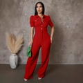 Detail of red short-sleeve jumpsuit showing the notched lapel and button closure - Burgundy