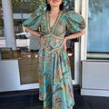 Vestido largo bohemio con estampado paisley, mangas de linterna y escote en V profundo - 2XL / Estampado verde azulado / [atributos Del Producto] La Imagen Muestra Un Vestido Largo Estampado De Estilo Bohemio Retro. El Color Principal Es Verde Turquesa Cubierto De Delicados Estampados De Cachemir Y Florales. Los Detalles Del Diseño Incluyen Un Escote En V Profundo Mangas Abullonadas Exageradas Y Un Cinturón Decorativo En La Cintura. La Falda Se Ensancha En Forma De Línea A. La Tela Parece Ser Algodón-lino O Seda. [presentación Visual] La Imagen Es Una Foto Real Tomada Con Una Modelo Frente A Una Tienda Con Reflejos De La Calle Y Marcos De Edificios Visibles En El Fondo. La Calidad De La Imagen Es [alta] Con Una Excelente Reproducción De Detalles. El Atractivo Estético Se Califica Como [medio] Con Una Puntuación General De [7.5]. Los Principales Problemas Son Un Fondo Bastante Soso Y Una Iluminación Ligeramente Dura Que Carece De Una Sensación De Amplitud. [contenido De Texto] No Hay Texto De Marketing Visible Logotipo De Marca Ni Marca De Agua En La Imagen. [etiquetas Logísticas] Ninguna. [riesgo De Infracción] El Producto Está Diseñado Como Ropa De Mercado Masivo Sin Logotipos De Marca Específicos Ni Diseños Patentados. La Probabilidad De Infracción Es [0.0]. No Hay Elementos De Marca En El Fondo. [parámetros Del Producto] Escote En V Mangas Abullonadas Estampado Vestido Largo.