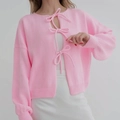 Détail du cardigan rose tricoté avec fermetures à nœuds et manches lanterne chic - S / Rose