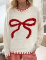 Detailed view of white knit sweater featuring red bow jacquard and contrast stitching - S / White