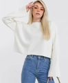 Close-up of white cropped knit sweater with ribbed cuffs and hem on a model - S / White
