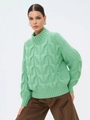 Dettaglio della spessa trama a trecce verde menta di un maglione ampio a collo alto - verde chiaro