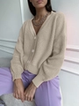 Dettaglio del cardigan in maglia grossa beige con scollo a V e grandi bottoni coordinati - Taglia unica / Cachi