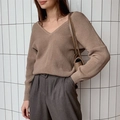 Detail of loose-fit V-neck knit sweater in tan with heavy knit texture and metal chain bag - Khaki