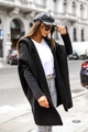 Detail of black hooded knit cardigan featuring chunky texture and dropped shoulders - Black