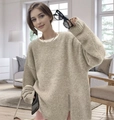 Dettaglio dello spacco laterale su un maglione in maglia beige oversize da donna - S / Cachi