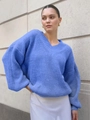 Close-up of blue oversized V-neck knit sweater showing ribbed cuffs and lantern sleeve detail - Sky Blue