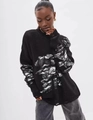 Detail shot of distressed black knit sweater showing oversized ripped fringe texture - Black