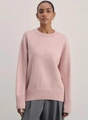 Detail of soft pink cashmere knit sweater showing ribbed crew neck and loose shoulder fit - Pink