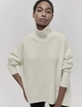 Close-up of ribbed knit texture on beige oversized turtleneck sweater cuffs and hem - S / Off White