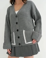 Detailansicht der dunkelgrauen Strickjacke mit V-Ausschnitt und weißen Taschenpaspeln - S / Grau