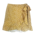 Detalle de falda cruzada amarilla con estampado floral, lazo en cintura y bajo volante - S / Amarillo