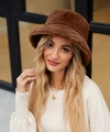 Close-up of thick dark brown faux fur bucket hat with soft plush texture for winter warmth - Coffee