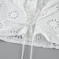 Detailed close-up of Broderie Anglaise cotton top with embroidery and lace-up waist detail - S / Tops / White