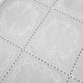 Detailed macro view of white floral embroidery and eyelet hollow design on fabric - S / White