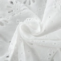 Dettaglio macro del tessuto in cotone bianco con ricamo floreale e pizzo sangallo - Taglia S / Top / Bianco