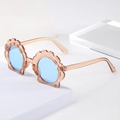 Detalle de gafas de sol para niños en forma de concha con montura de purpurina - Café Cristal