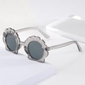 Detail view of translucent grey shell-shaped kids sunglasses with silver glitter accents - Crystal Gray