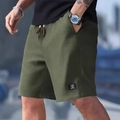 Detail of army green waffle knit fabric texture and logo patch on men's casual shorts - S / Army Green