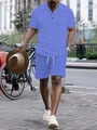 Outdoor street view of men's summer short sleeve polo and shorts set with blue geometric pattern - S / Blue