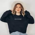 Close-up of black fleece sweatshirt featuring white you are enough slogan print - S / Black