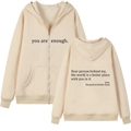 Detail of apricot hoodie showing drawstring hood, front zipper, and printed typography text - S / Khaki