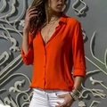 Detail of a bright orange long-sleeve button-down shirt with elegant lapel collar design - S / Orange