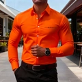 Detail of slim-fit orange men shirt featuring black script logo and white buttons on the chest - S / Orange