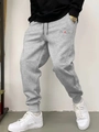 Detail of men's grey jogger pants with black drawstring and red accent letter print - S / BLACK Print-Light Gray