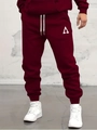 Detail view of burgundy men's jogging pants featuring a white triangle logo and ribbed cuffs - S / Triangle A Print-Red