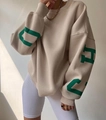 Detail eines beigen Oversize-Sweatshirts mit dunkelgrünem Buchstabendruck und Rippbündchen - S / Khaki