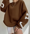 Detail eines braunen Oversize-Sweatshirts mit weißem Buchstabendruck an Ärmeln und Rippbündchen - S / Kaffeebraun