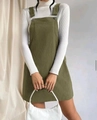 Detail view of olive green corduroy pinafore dress with large pockets and v-neck line - S / Green