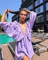 Detail of lavender deep V-neck mini dress with lantern sleeves by a sunny pool - S / Purple