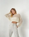 Close-up of cream crochet crop top with hollow texture and wide leg striped pants - Off White