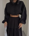 Detail of black two-piece set featuring a cropped lace-up top and tiered maxi skirt - S / Black