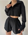 Dettaglio del top polo corto nero a maniche lunghe e pantaloncini a vita alta a taglio vivo - S / Nero