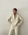 Dettaglio del collo alto con mezza zip e tessuto in pile spesso sul set beige a due pezzi - S / Albicocca