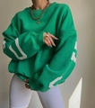 Détail d'un sweat-shirt vert vif oversize à col rond avec lettrage blanc sur manches - S / Vert