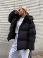 Outdoor shot of a woman in a black hooded puffer jacket with loose fit for winter - S / Tops / Black