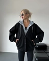 Dettaglio di un blazer nero oversize a strati con una felpa grigia con cappuccio - S / Nero