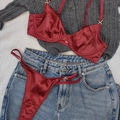 Dessous-Set aus weinrotem Satin mit Bügel-BH und Tanga auf flach gelegtem Outfit - Burgunderrot