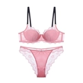 Rosa Spitzenunterwäsche-Set mit schwarzen Trägern und passendem Slip flach liegend - Rosa